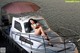 A woman in a bikini sitting on a boat.