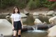 A woman standing in front of a body of water.