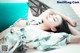 A woman laying on a bed with her eyes closed.