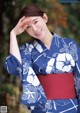 A woman in a blue and white kimono posing for a picture.