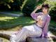 A woman in a purple and white dress sitting on a rock by a pond.